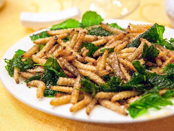 Deep-fried "bamboo worms" Yunnan specialty food - deep fried bamboo worms served at a Yunnan cuisine restaurant in Beijing, China. moth larvae pictures pictures stock pictures, royalty-free photos & images