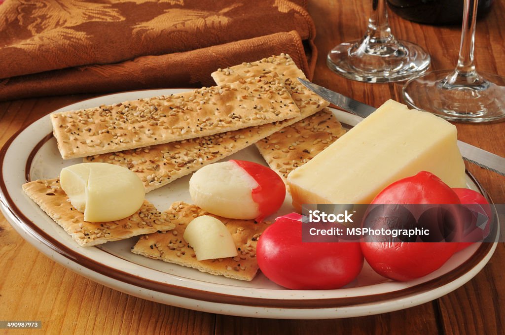 Asiago and assorted cheeses A wedge of asigo cheese with assorted cheeses in a red wax wrapper Asiago - Cheese Stock Photo