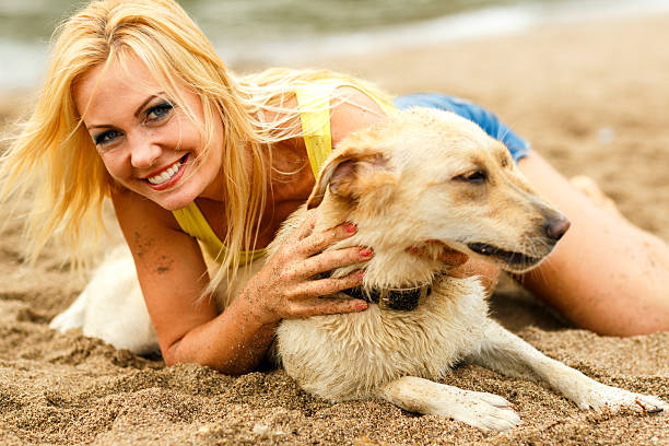 istock Woman with dog playing on the beach 490989890