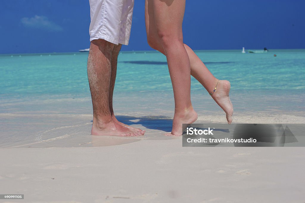 Zbliżenie mężczyzny i kobiety stopy na biały piasek - Zbiór zdjęć royalty-free (Flirtować stopami)
