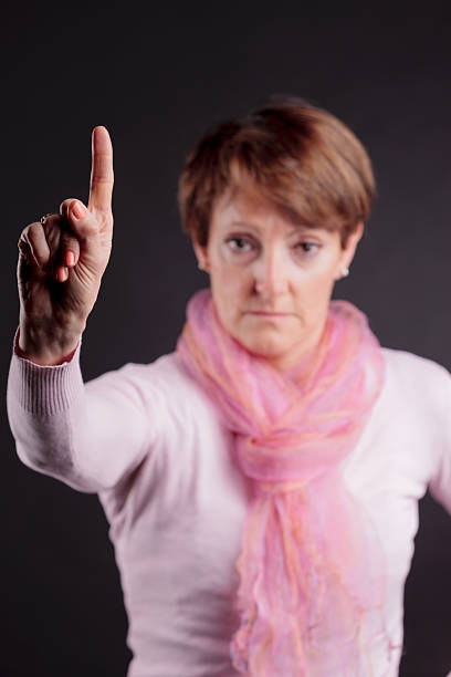 istock mature woman with a raised hand saying NO 490992473