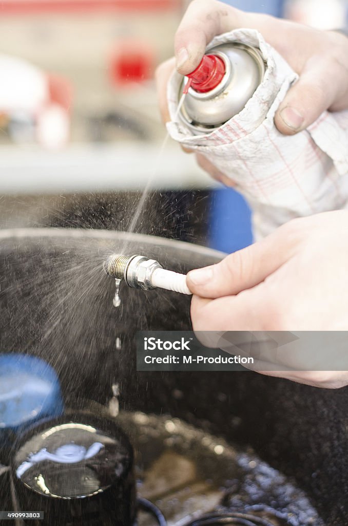Spark plug cleaning in repair shop. Candle Stock Photo