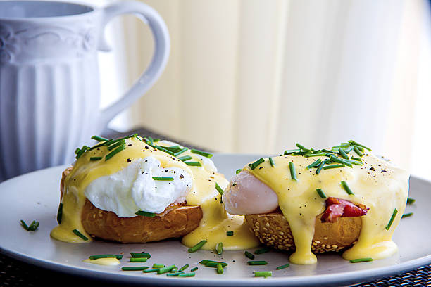 Eggs Benedict and delicious buttery hollandaise sauce Eggs Benedict- toasted English muffins, ham, poached eggs, and delicious buttery hollandaise sauce hollandaise sauce stock pictures, royalty-free photos & images