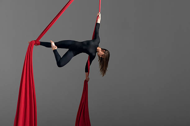 Girl performing aerial silk dance Sporty woman doing exercise with elastics, aerial silk ribbons. Sport training gym and lifestyle concept. Anti-gravity yoga. acrobatic activity stock pictures, royalty-free photos & images
