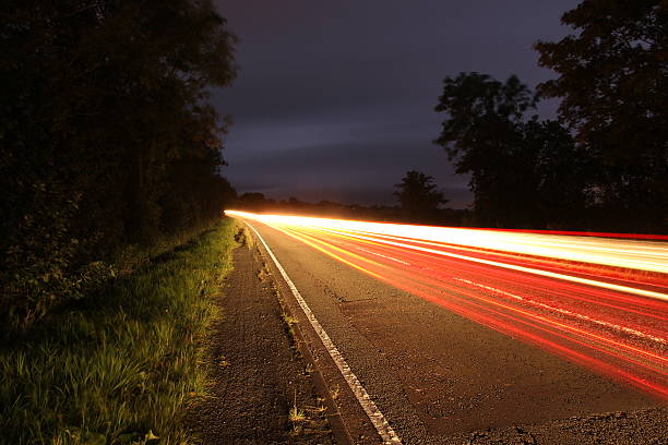 istock Long exposure vehicle lights country road 490996510