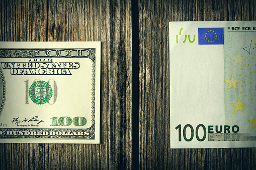 US and euro currency over wooden background