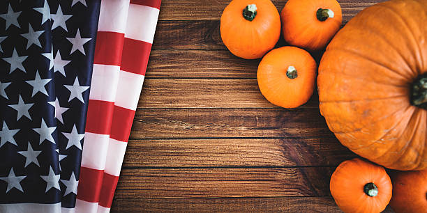 istock halloween pumpkin on rustic wood with usa flag 491027692