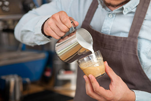 istock Cheerful young barista is brewing coffee in cafe 491045766