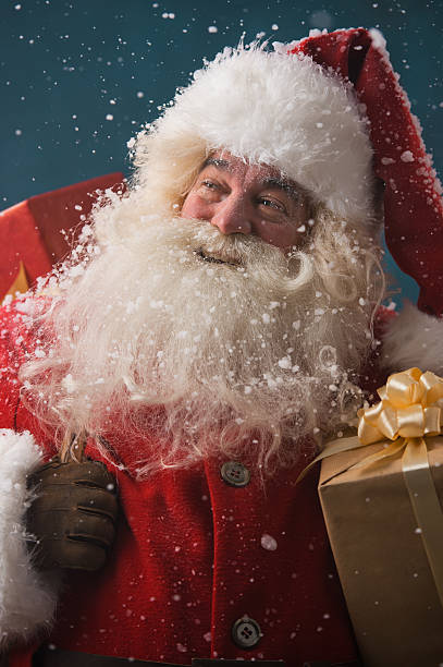 istock Claus outdoors in snowfall carrying gifts 491057874