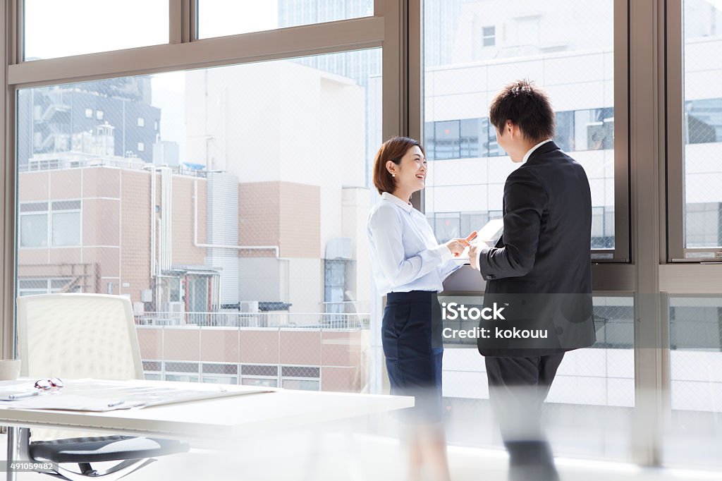 Businesswoman to show the tablet to the man at window Businesswoman to show the tablet to the man at the window Adult Stock Photo