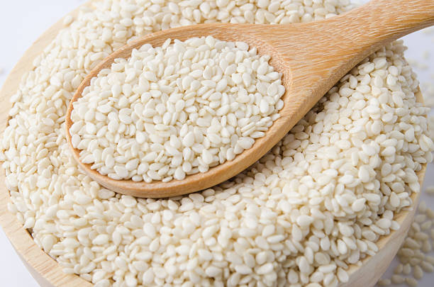 istock sesame seeds with wooden spoon 491059524