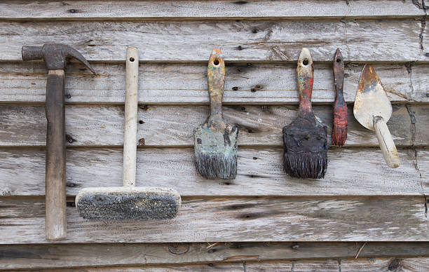 istock Old paint brush and hammer on wood background 491060402