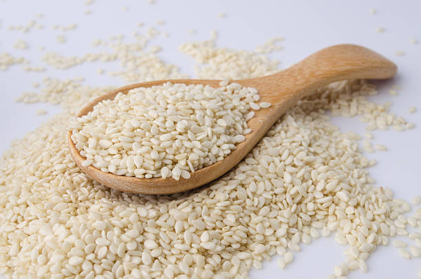 istock sesame seeds with wooden spoon 491063218