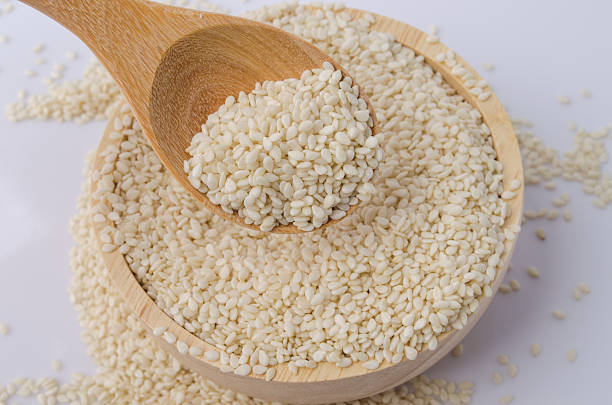 istock sesame seeds with wooden spoon 491063438