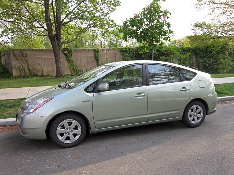 Washington DC, USA-May 4, 2014:  This green second generation Toyota Prius was spotted in a quiet North West Washington DC neighborhood.  It is popular amongst drivers who want to save money on gas or who want to lessen their environmental impact.  This car delivers 48 MPG city and 45 MPG highway by employing a hybrid electric motor and gasoline engine power train.