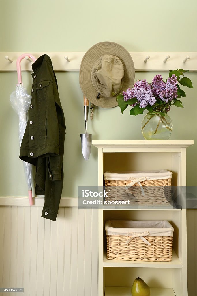 Mudroom in the Warm Weather Months A home mudroom, with storage baskets and coat pegs, shown here with warm weather items. Basket Stock Photo