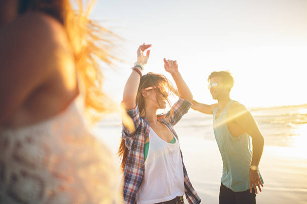 istock Friends dancing on beach in sunset 491068285