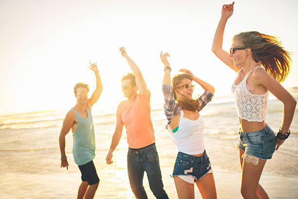 istock Friends dancing on beach in sunset 491068289