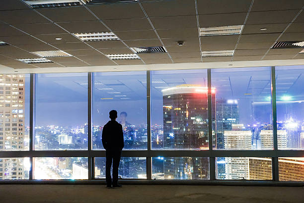 istock Businessman looking at cityscape from office window 491070072