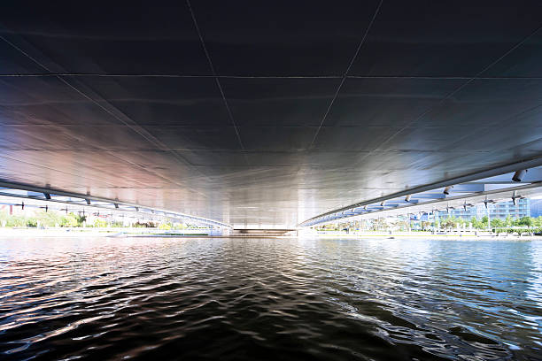 istock flowing river below bridge of modern city 491070864