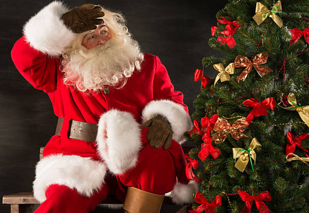 istock Santa Claus decorating Christmas tree in dark room 491071478