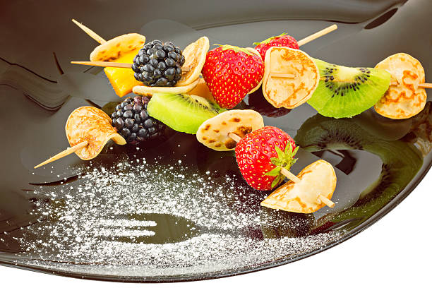 istock Fruit, Berries and mini blini kebab on black plate 491075038