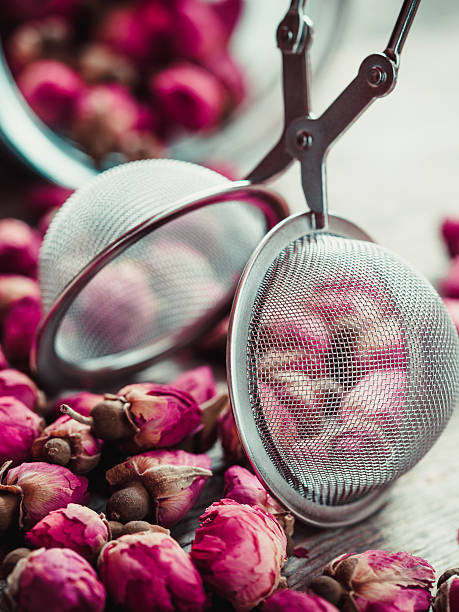 istock Rose buds tea, tea infuser and glass jar closeup. 491075782