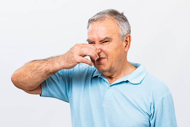 Unpleasant smell Senior man doesn't like how something smells. holding nose stock pictures, royalty-free photos & images