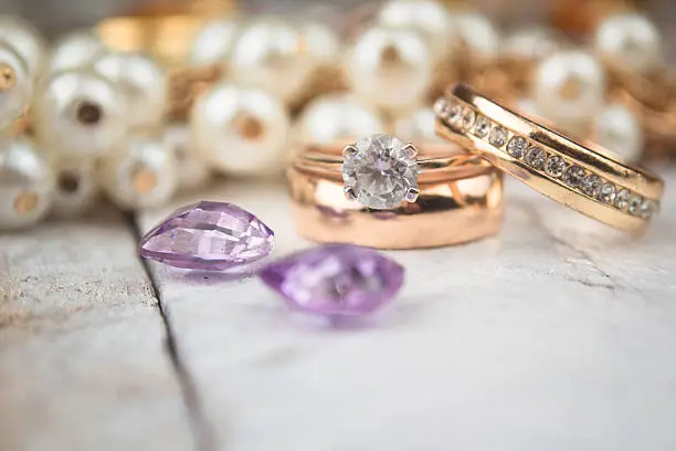 Photo of Golden wedding rings on white wood background