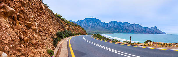 Faure Marine Drive from Gordon's Bay, Cape Town Faure Marine Drive from Gordon's Bay, with False Bay, and the sandtone rock feature seen on the left. A seaside coastal route leading south towards Betty's Bay in Cape Town. gordons bay stock pictures, royalty-free photos & images