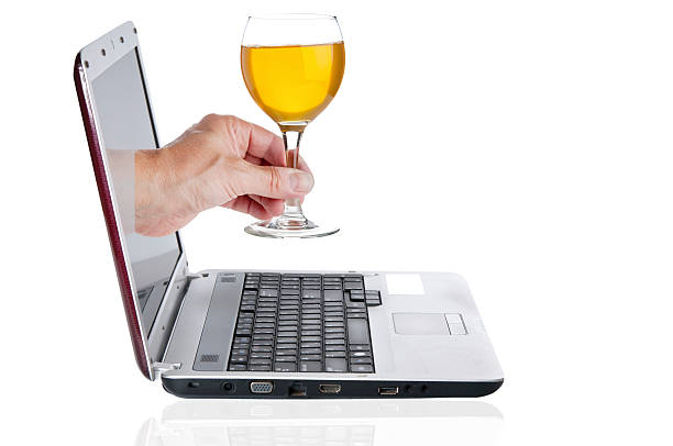 istock Hand with goblet with wine comes from the laptop screen 491102568