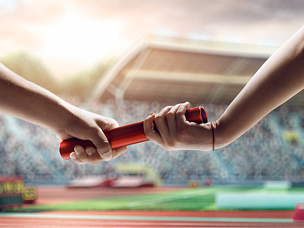 istock Close up of exchanging relay baton on a race 491104742