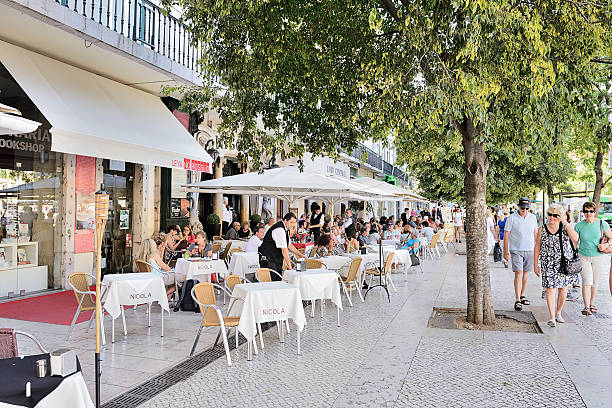 Lisbon, Portugal - July 4, 2015:  People relaxing at a pavement cafe on the Praca Do Comercio Square, in Lisbon. Waiters serving
