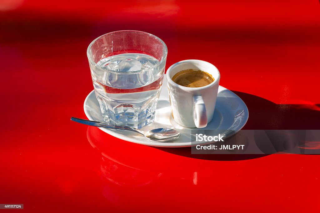 Coffee and water glass Coffee and glass of water on a red table. Easily cut out. 2015 Stock Photo