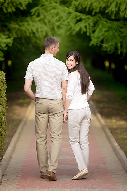istock Young man and woman walking in park 491117262