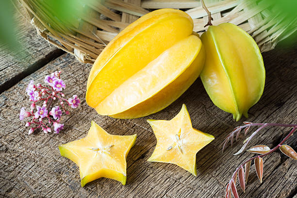 star fruit star fruit and piece with it's flower and leaf on old wood starfruit stock pictures, royalty-free photos & images