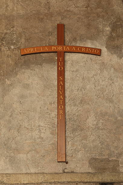 istock Cross on a old stucco wall with inscription on italian 491118394