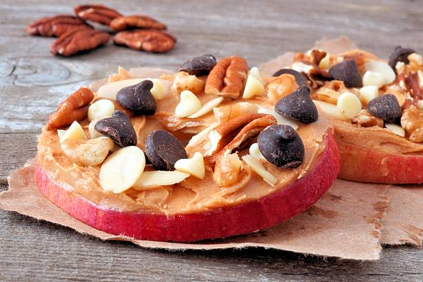 istock Apple rounds close up with peanut butter, chocolate and nuts 491119700