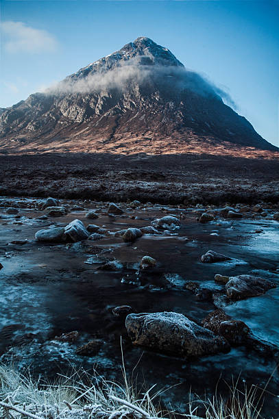 Buachaille Etive Mor in winter. (portrait format) The iconic Scottish mountain, a favourite with rock climbers around the world, is pictured here in portrait format in December. The River Etive is in the fore ground and is starting to freeze. etive river photos stock pictures, royalty-free photos & images