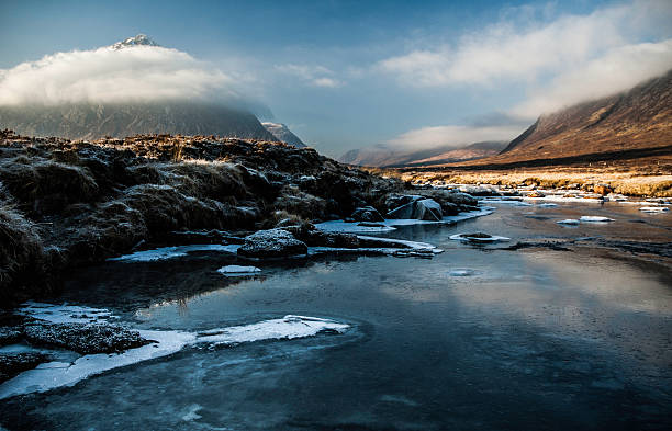 Buachaille Etive Mor in winter. The iconic Scottish mountain, a favourite with rock climbers around the world, is pictured here in December. The River Etive is in the fore ground and is starting to freeze. etive river photos stock pictures, royalty-free photos & images