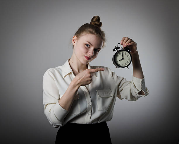 niña señalando en un reloj. - deadline urgency calendar women fotografías e imágenes de stock