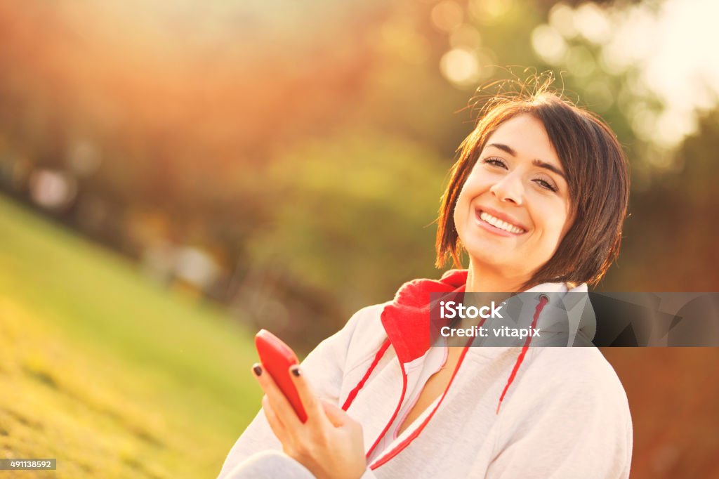 Young woman using mobile telephone outside Portrait of young woman wearing sports clothing using mobile telephone. 20-29 Years Stock Photo