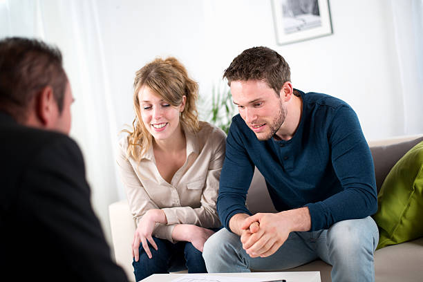 istock cheerful young couple with a consultant salesman 491141271