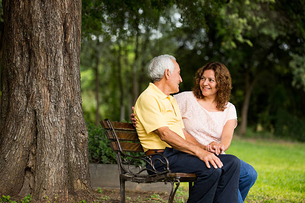 Father sitting with daughter in park A elder father sitting with his daughter in the park. father daughter 80s stock pictures, royalty-free photos & images
