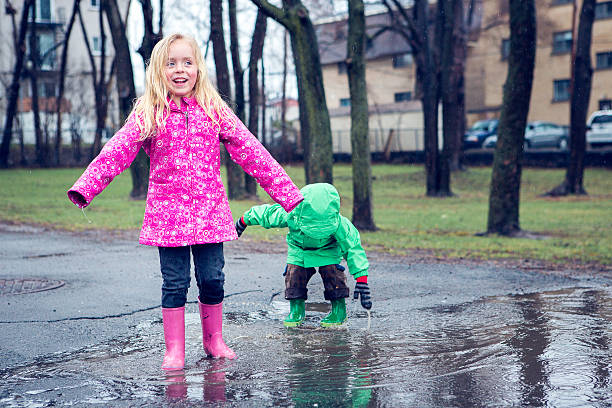 istock Little boy and girl in puddle 491142295