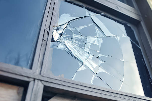 broken glass Broken glass window reflecting blue sky. mann stock pictures, royalty-free photos & images