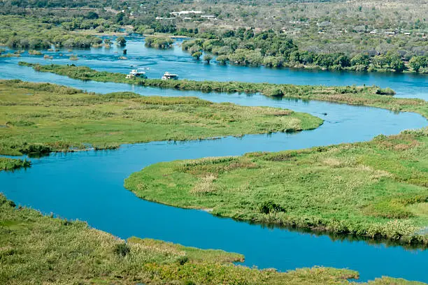 Aerial view of water channels along Chobe River with two tour boats cruising through the water in the distance in the eastern end of the Caprivi Strip, Namibia, Africa