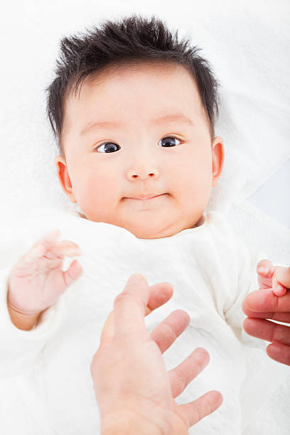 istock cute and smiling infant  with mother hands 491146837
