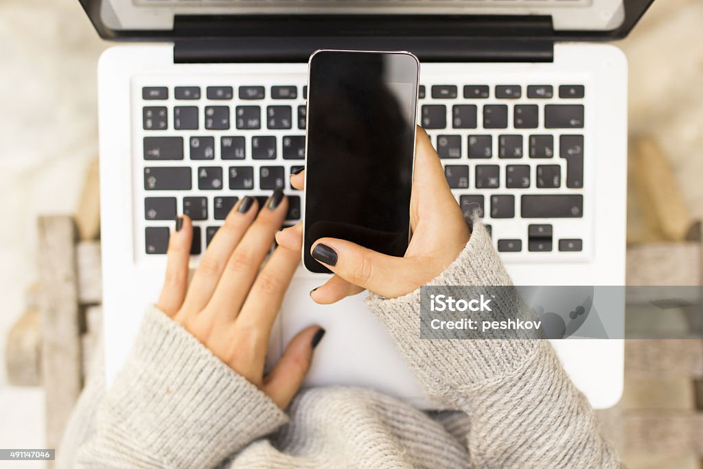 Girl with cell phone and laptop 2015 Stock Photo