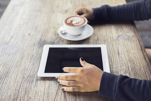 istock Girl hands, digital tablet and coffee on a wooden table 491147232